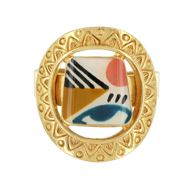 Image of quirky round ring with hand painted multicolour motif in centre on gold metal finish.