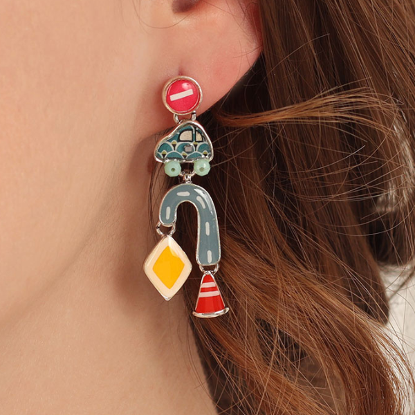 Image of model wearing bright hand painted car earrings with roads and hazard signs as dangles on silver finish.