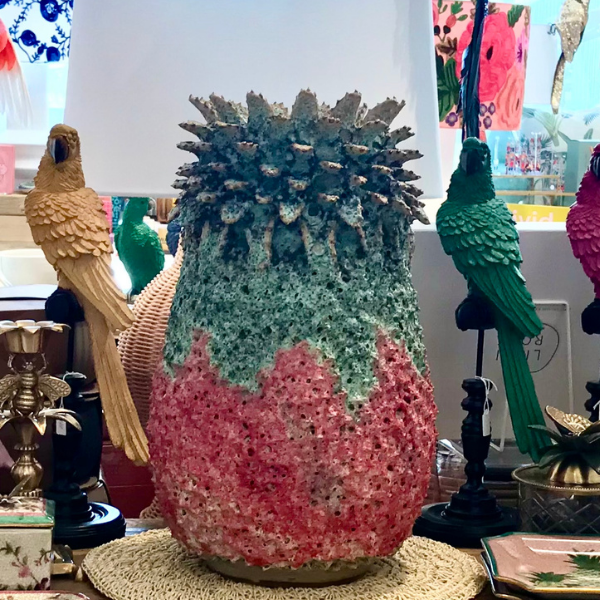Image of an impressive, heavy based vase shaped as a pineapple. Strawberry and green base with green leaves. A quirky decor item that will form a very special centrepiece.
