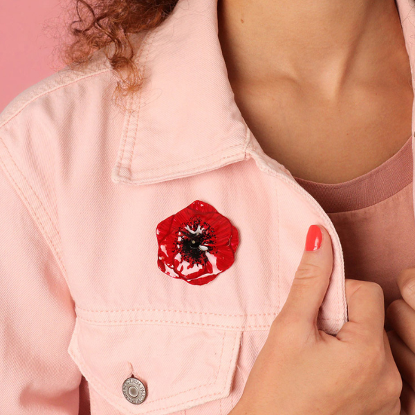 Image of model wearing cute red hand painted poppy brooch with rhinestone centrepiece.