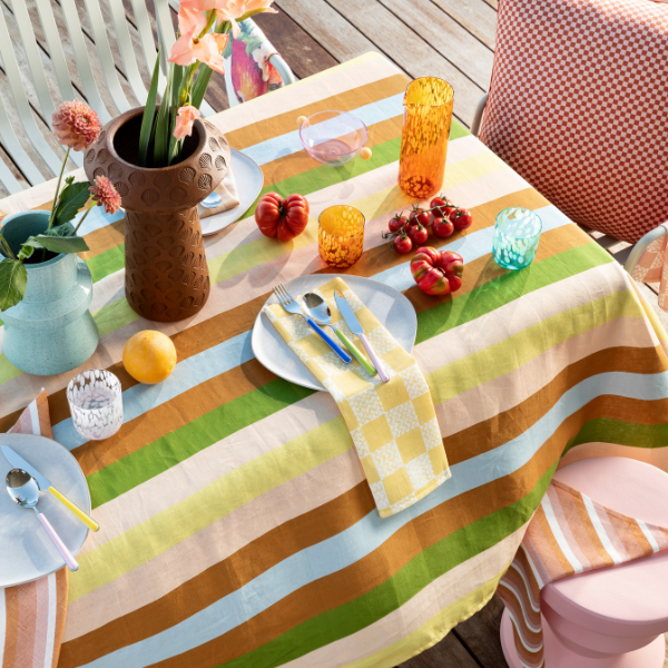 Image of table setting featuring linen tablecloth in early colour stripes.