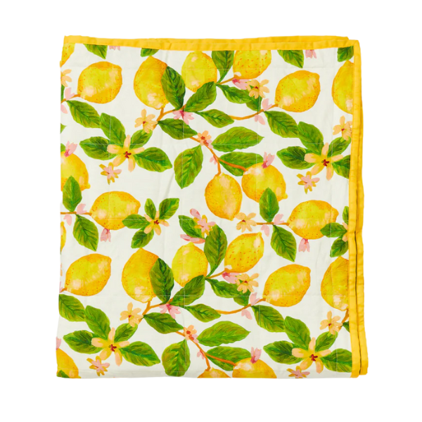 Image of linen quilted throw with capri print. Lemon pattern on cream background. Contrast cotton edging.