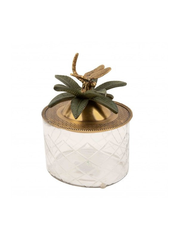 Image of round glass trinket box with brass lid that has dragon fly handle surrounded by brass green leaves.