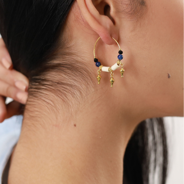 Image of model wearing hoop earrings beaded with bone, gold plated metal beads, lapis and dark Swarovski crystals.