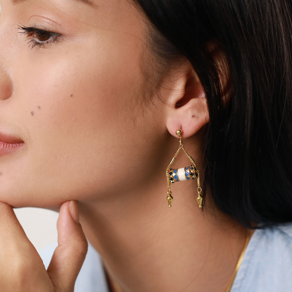 Image of model wearing drop earrings in a Middle Eastern style with bone, lapis and swarovski embellishments.