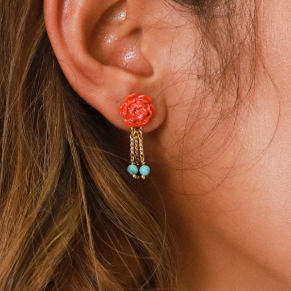 Image of model wearing pretty peony flower stud earrings with 3 gold chain dangles that have turquoise and black beads on the end.