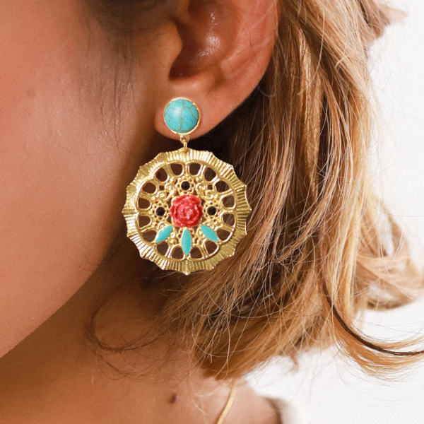 Image of model wearing gypsy style earrings on gold plated disc with peony flower and black and turquoise beads in the disc.