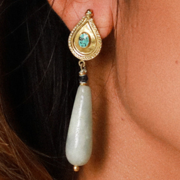 Image of model wearing long milky aqua dangle earrings.