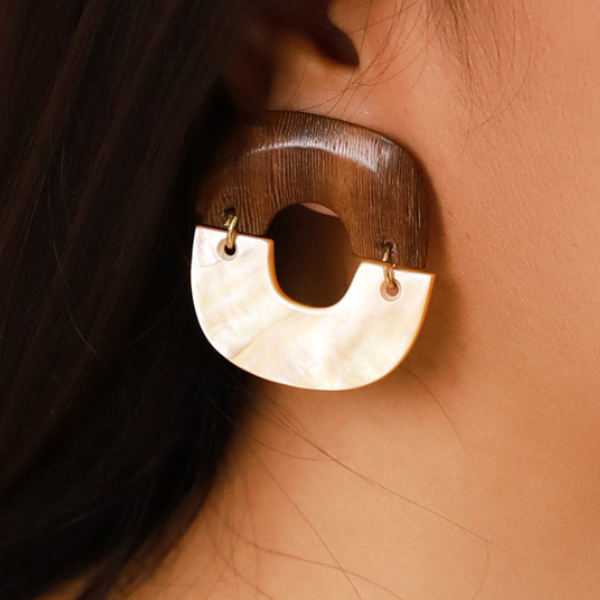 Image of model wearing big square earrings made from golden mother-of-pearl and robles on gold stud finish.