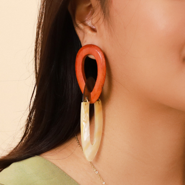 Image of model wearing 2 rings dangle earrings made from Golden Mother of Pearl and jackfruit wood on gold stud finish.
