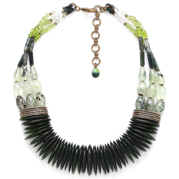 Image of statement necklace surrounded with a range of green beads, stones and quartz crystals.