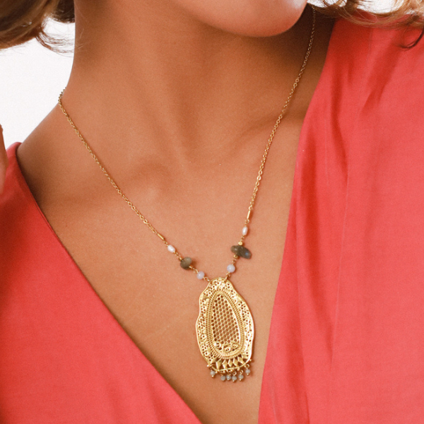 Image of model wearing necklace with large 18 carat gold plated lacey effect pendant that has mini dangle beads.