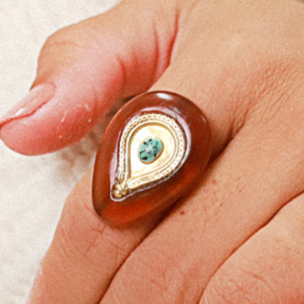 Image of model wearing chunky teardrop ring with gold and aqua centre.