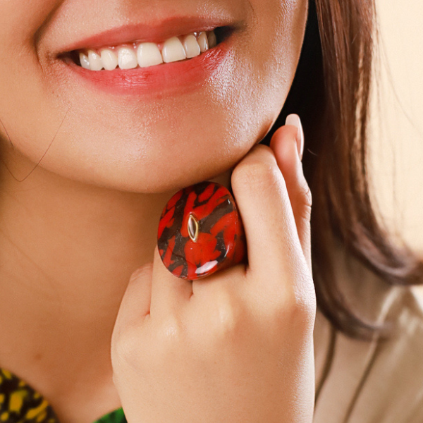 Image of model wearing chunky ring in termite mound red agate colour and theme.
