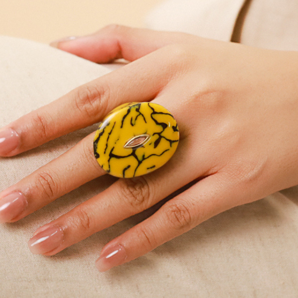 Image of model wearing chunky ring in termite mound citrin colour and theme.