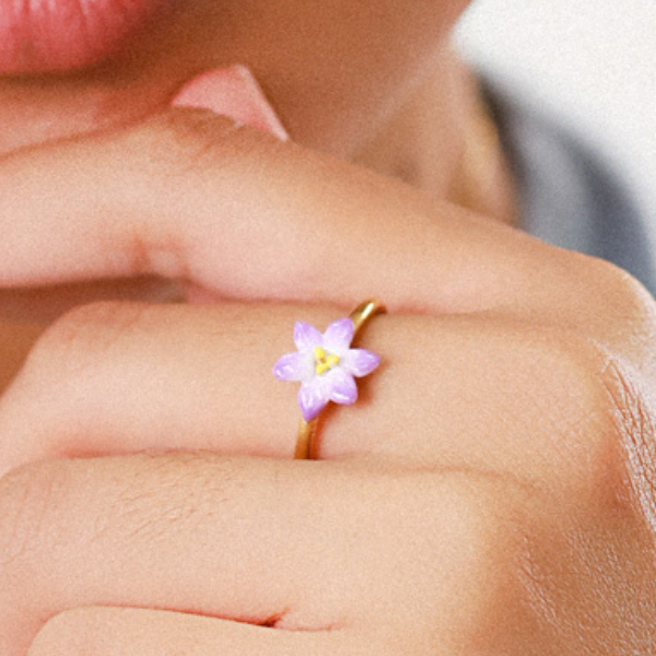 Image of model wearing dainty lilac flower ring.