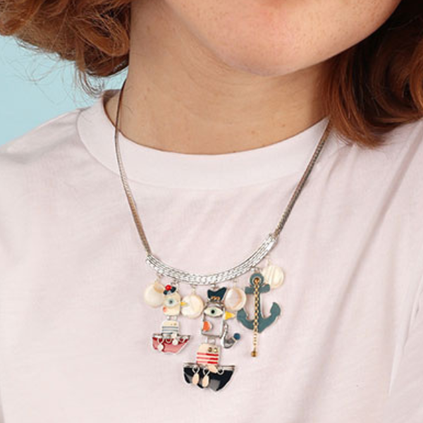 Image of model wearing quirky necklace featuring duck sailors in boats and anchor, all hand painted on silver metal chain.