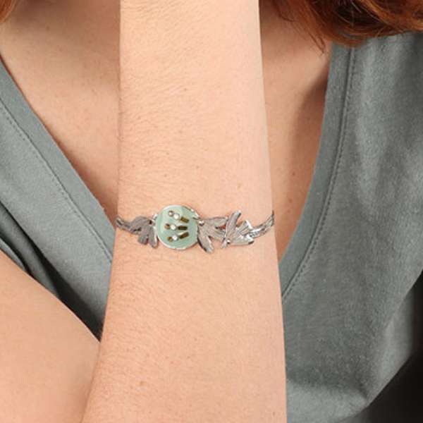 Image of model wearing pretty bracelet using birds as feature with hand painted blue resin and rhinestones on silver plated finish.