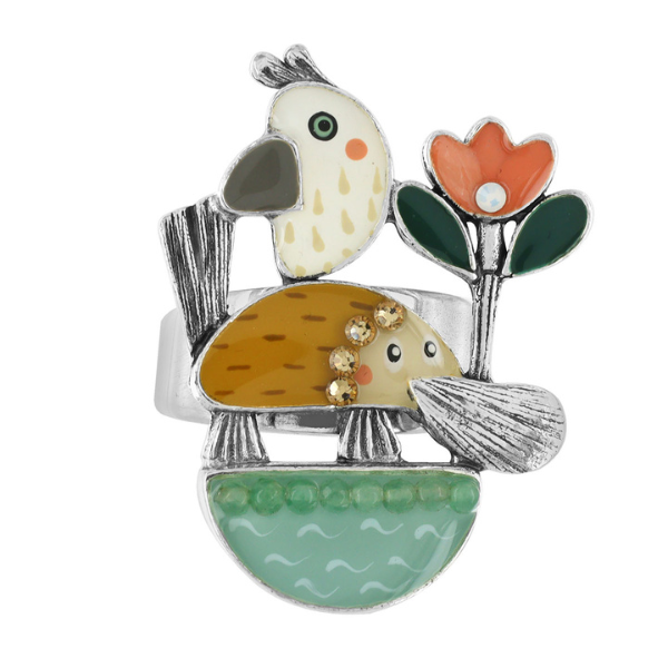 Image of quirky ring featuring hand painted platypus, flowers and bird on silver metal finish.