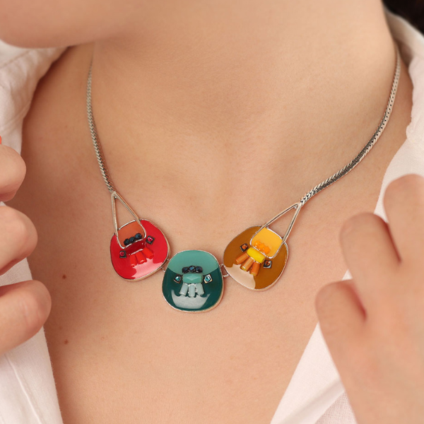 Image of model wearing hand painted 3 stones necklace with green, yellow and red on silver metal finish.