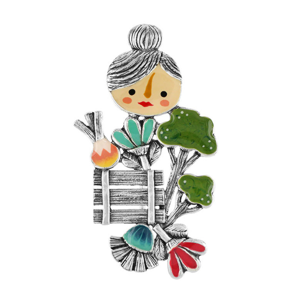 Image of brooch with character Leon Gherkin carrying market produce.
