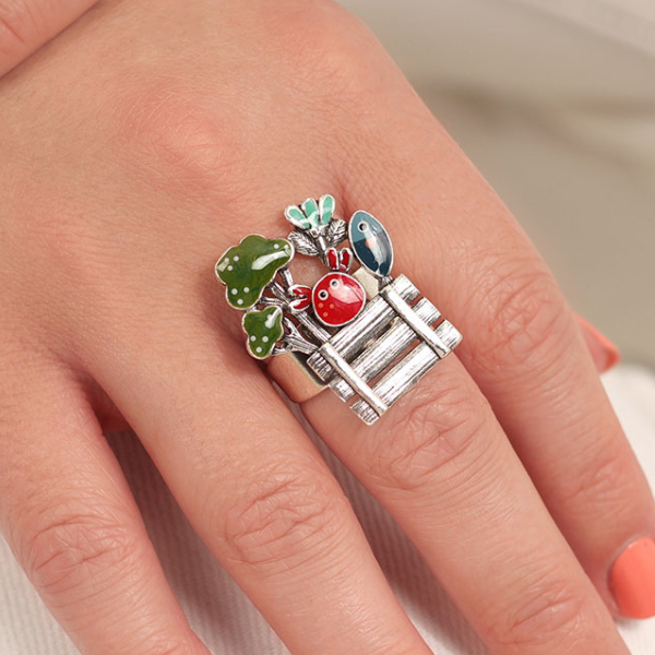 Image of model wearing quirky silver metal ring with market produce hand painted features.
