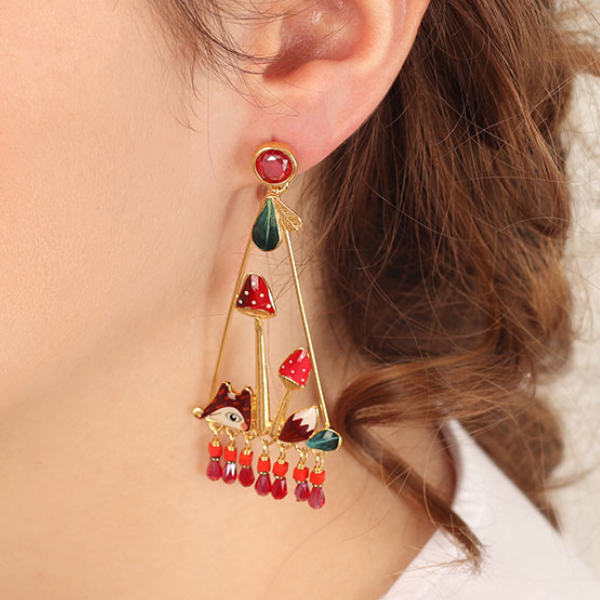 Image of model wearing large Triangular earrings with cute fox and red beads dangles.