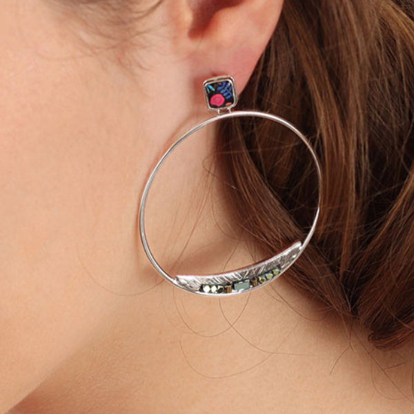 Image of model wearing hoop dangle earrings encrusted with hand painted patterns and stones in multicolours.
