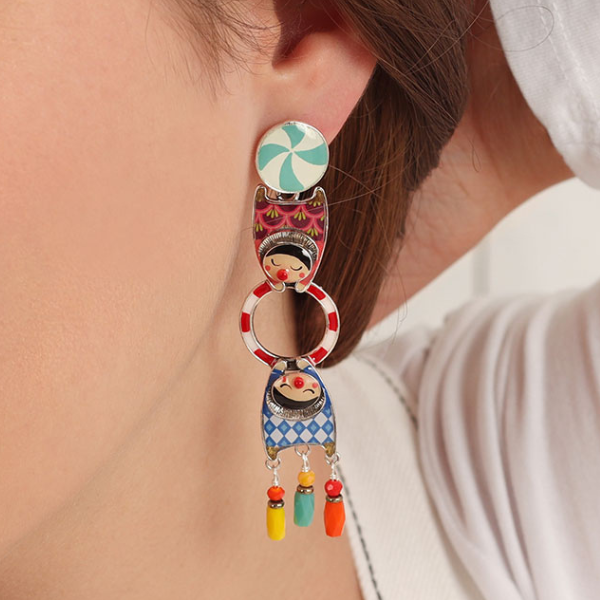 Image of model wearing colourful circus trapeze characters on silver finish dangle earrings.