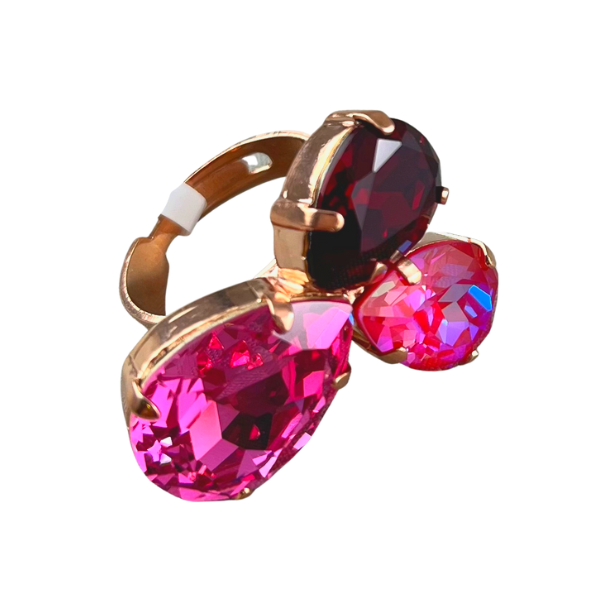 Image of adjustable statement ring with 3 tear drop crystals in pink tones and claret on 18ct rose gold plated metal.