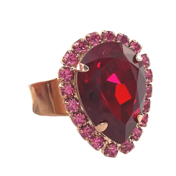 Image of dress ring featuring large red teardrop Swarovski crystal trimmed with pink seed crystals. 18ct rose gold plated band.