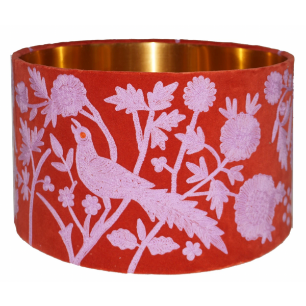 Drum lampshade with a red velvet base embroidered with pink peacock and flowers design. Copper coloured inner lining.