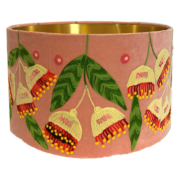 Image of blush pink velvet lampshade embroidered with cream and red gumnuts, and green leaves. Metallic gold coloured inner.