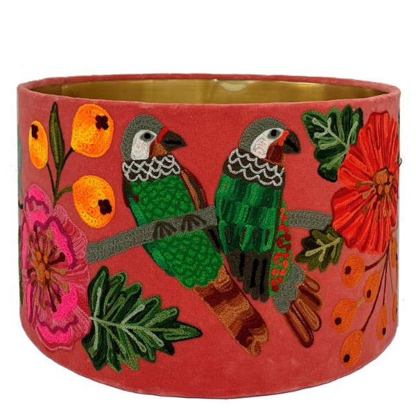 Image of watermelon velvet lamp shade embroidered with green parrots and yellow, pink and orange flowers.