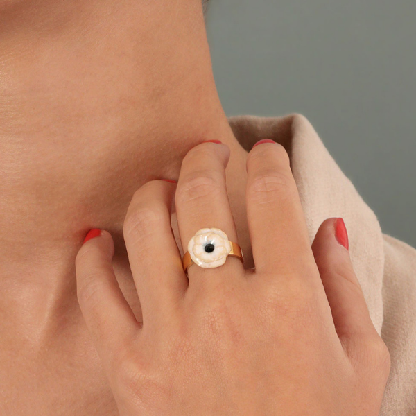 Image of model wearing an adjustable ring with cream and white flower with a black centre.