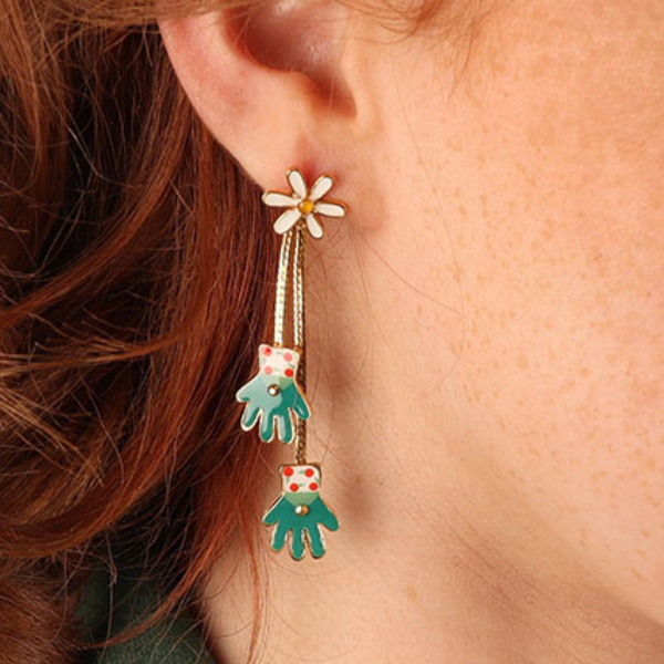 Image of model wearing quirky dangle earrings with 2 gardening gloves as features on gold metal finish.