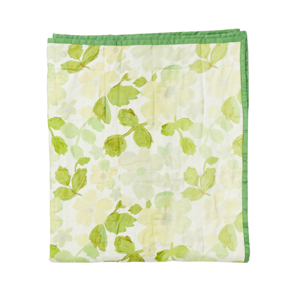 Image of linen quilted throw with floral print. Green flowers on cream background. Contrast cotton edging.