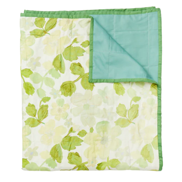 Image of linen quilted throw with floral print. Green flowers on cream background. Contrast cotton edging.
